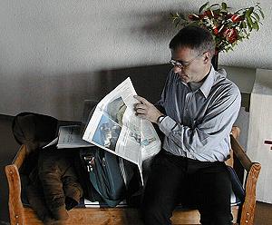 Er zieht eine Zeitung aus seiner Tasche